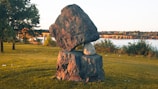 Outdoor shot of a large stone sculpture displayed in a sunlit garden.