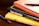 A stack of books is arranged on a wooden surface. The books include 'Aristotle's Nicomachean Ethics', 'Think & Grow Rich' by Napoleon Hill, and 'The Energy Bus'. Additionally, there are two fountain pens placed around the stack.