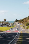 A community workshop where locals share stories about safe driving under palm trees with ocean in background.