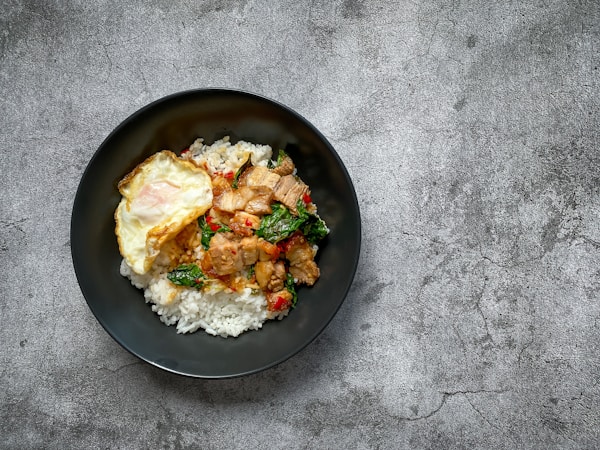 A black plate topped with rice and meat