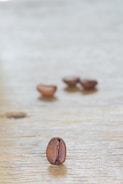 A close-up of coffee beans on a wooden table.