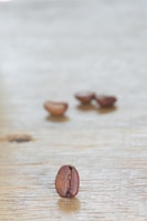 A close-up of fresh avocados and coffee beans on a wooden table.
