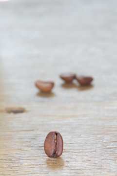 A close-up of coffee beans on a wooden table.
