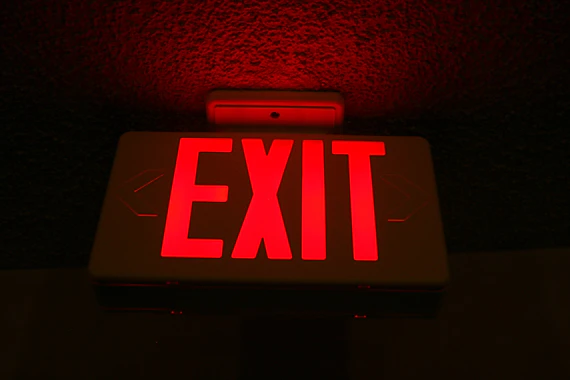 a red exit sign lit up in the dark