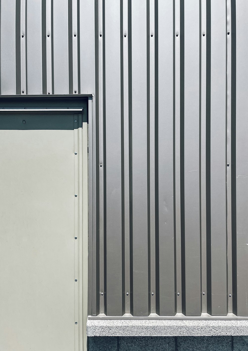une porte blanche assise à côté d’un mur métallique