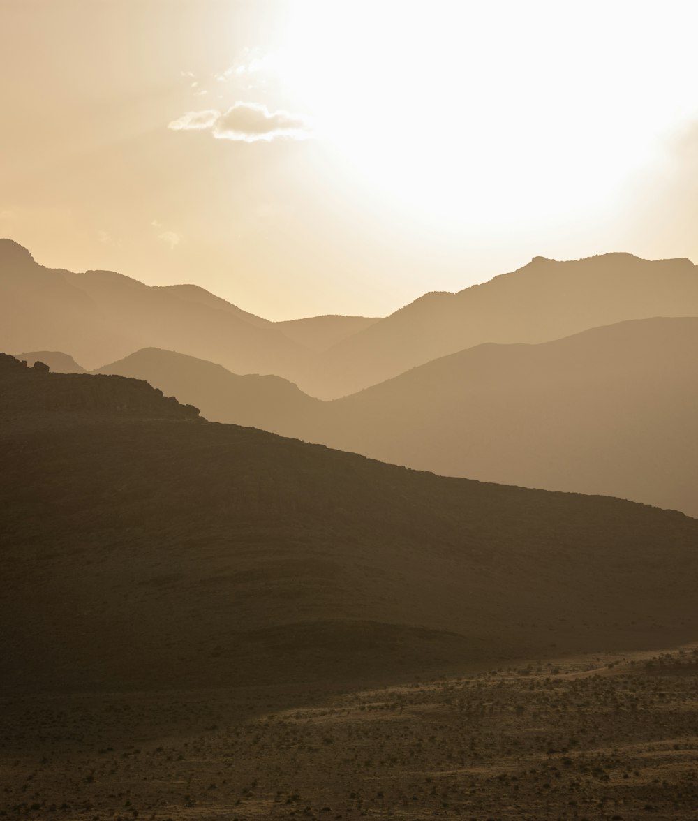 the sun is setting over the mountains in the desert