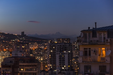 Cozy downtown apartment with city skyline visible at dusk.