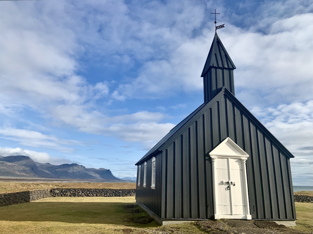 a small church with a steeple and a cross on top