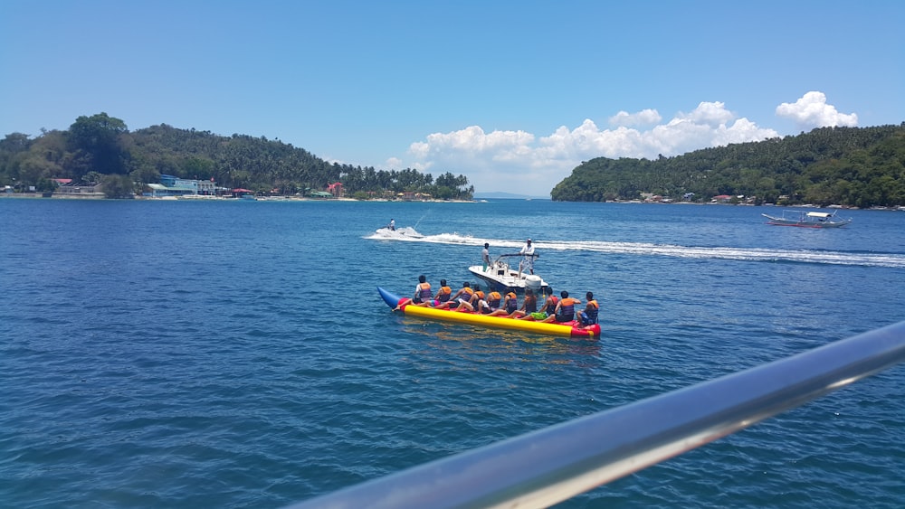 a group of people riding on the back of a yellow boat