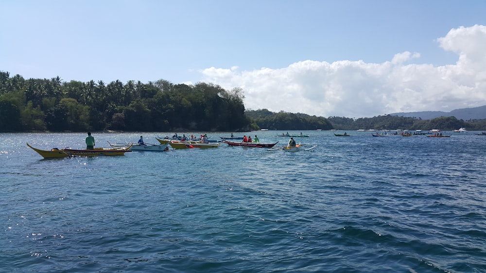 a group of people in canoes paddling on a lake