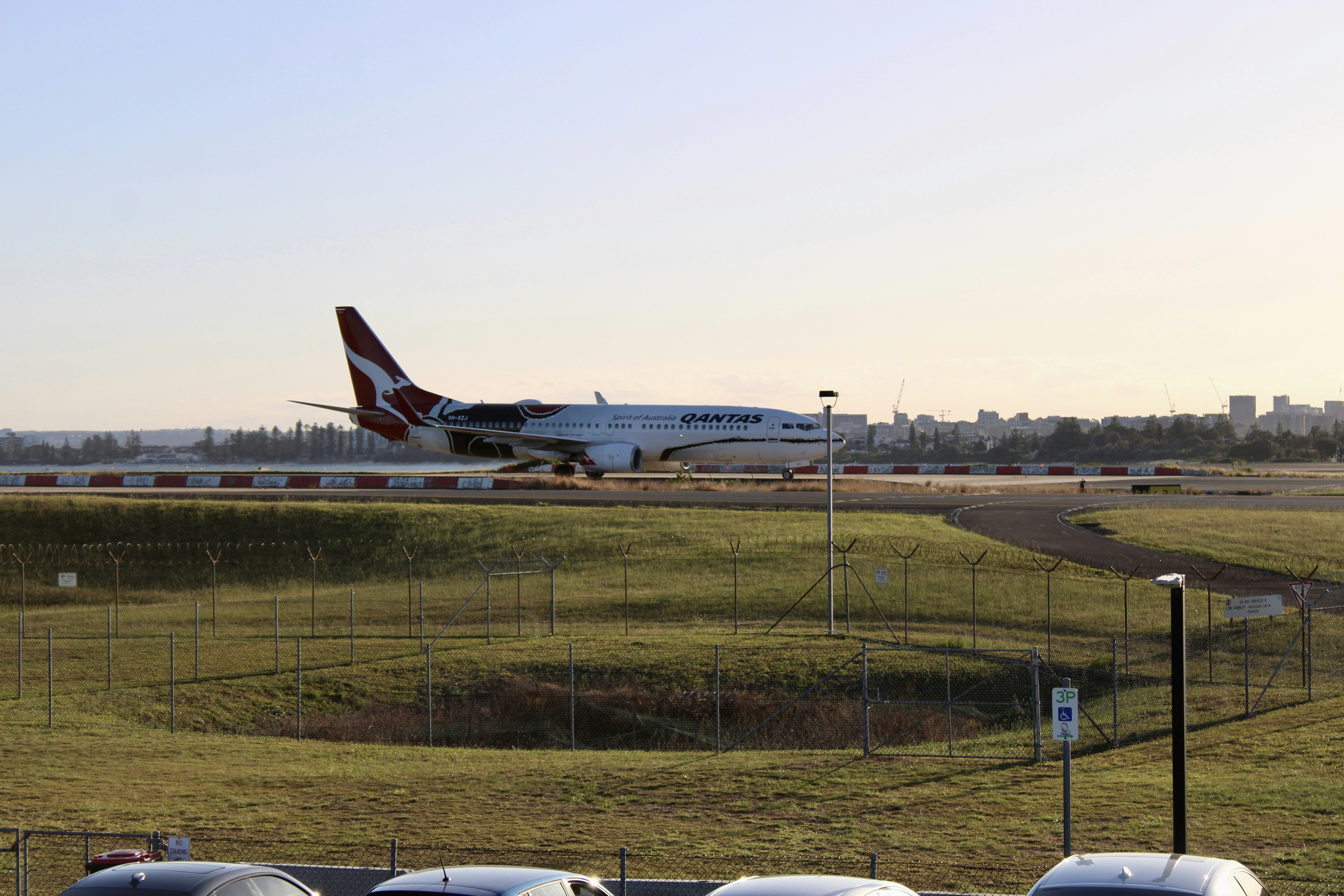 a large jetliner taking off from an airport runway, Qantas taxing down to DOM 1