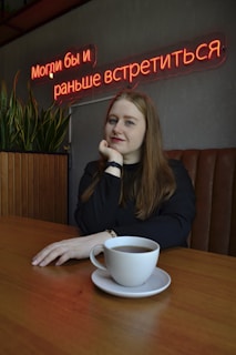 A person sitting at a coffee shop table, wearing a minimalist shirt that speaks volumes without words.