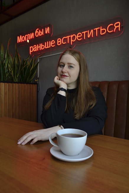 A person sitting at a coffee shop table, wearing a minimalist shirt that speaks volumes without words.