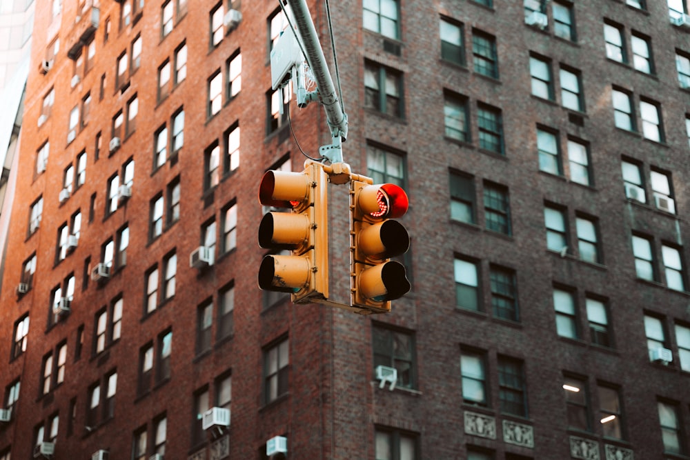 a traffic light hanging from the side of a tall building