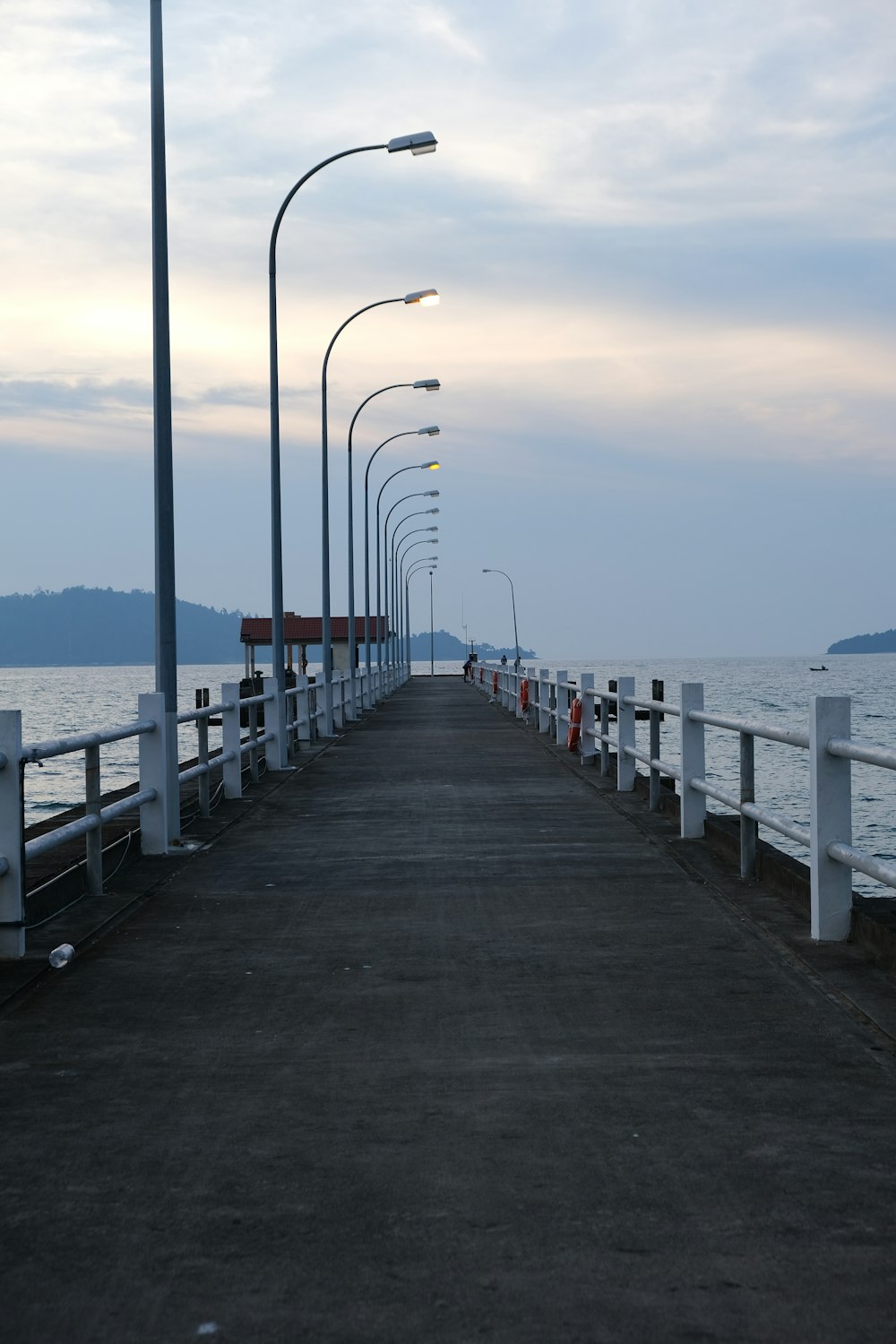 a long pier with a light pole and street lights
