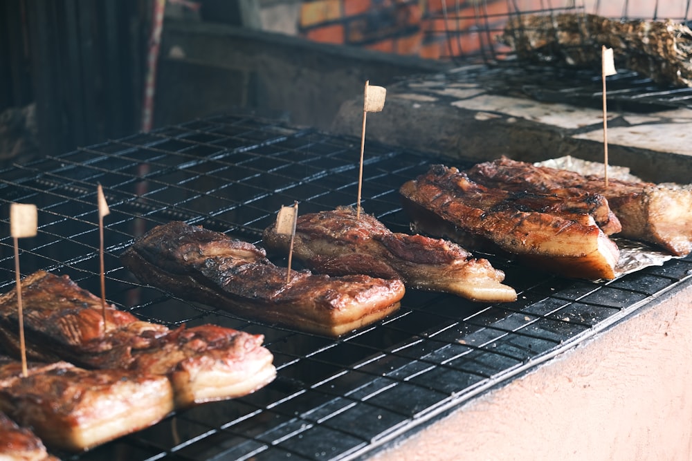 steaks and other meats cooking on a grill