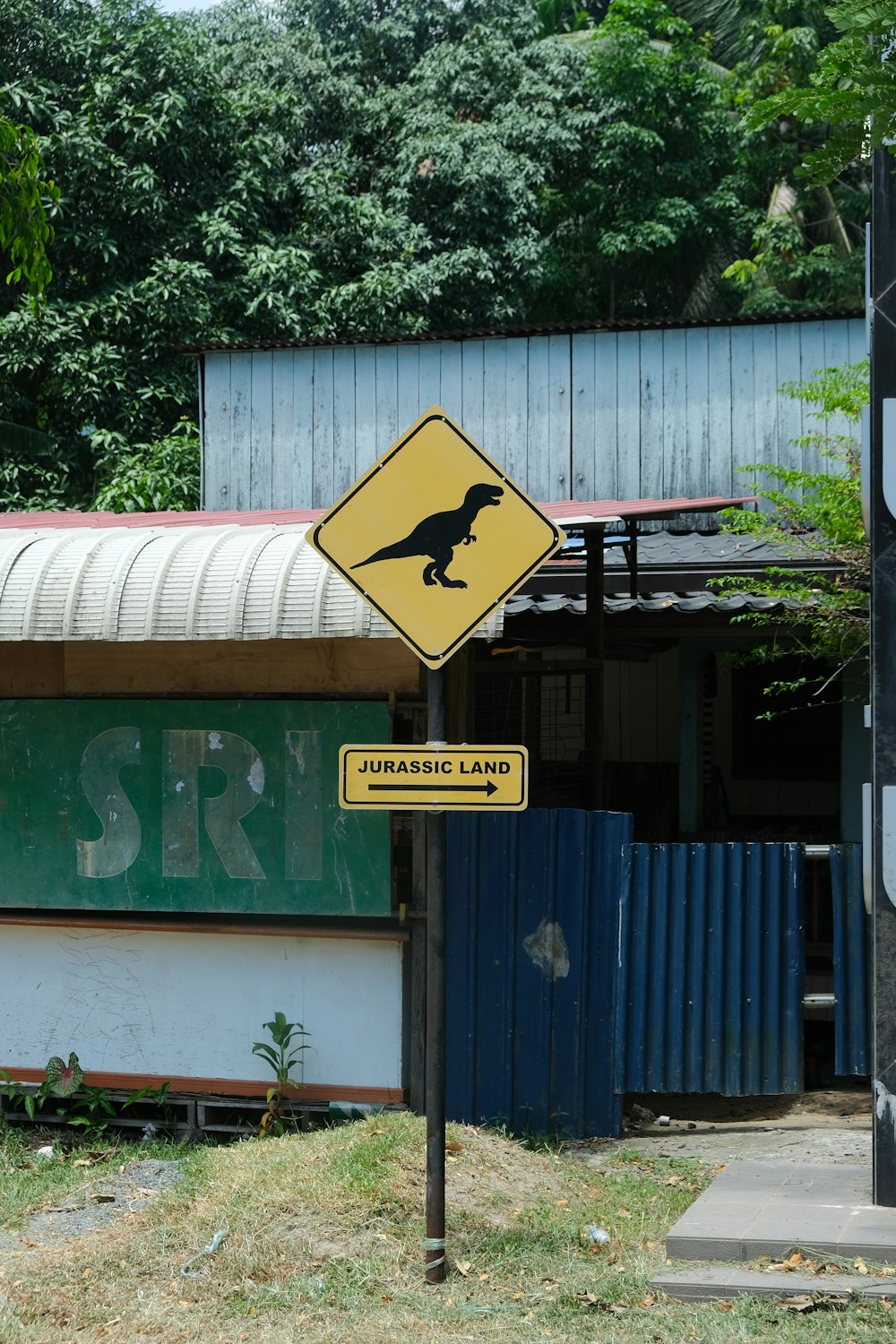 a yellow dinosaur crossing sign in front of a building