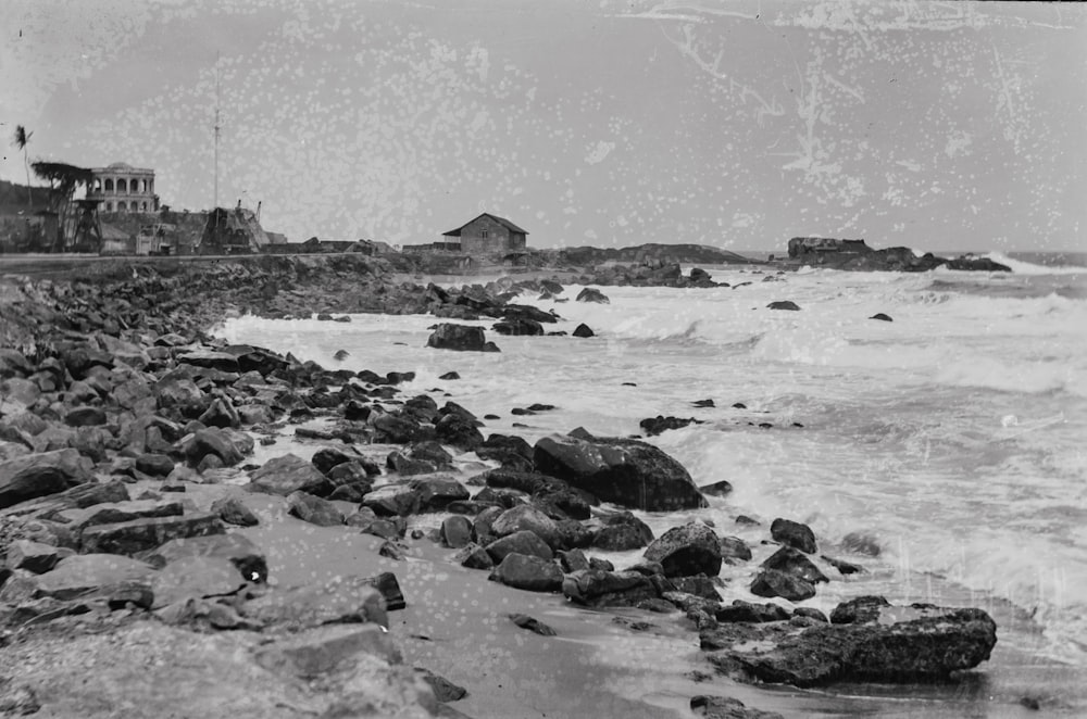 岩だらけのビーチの白黒写真