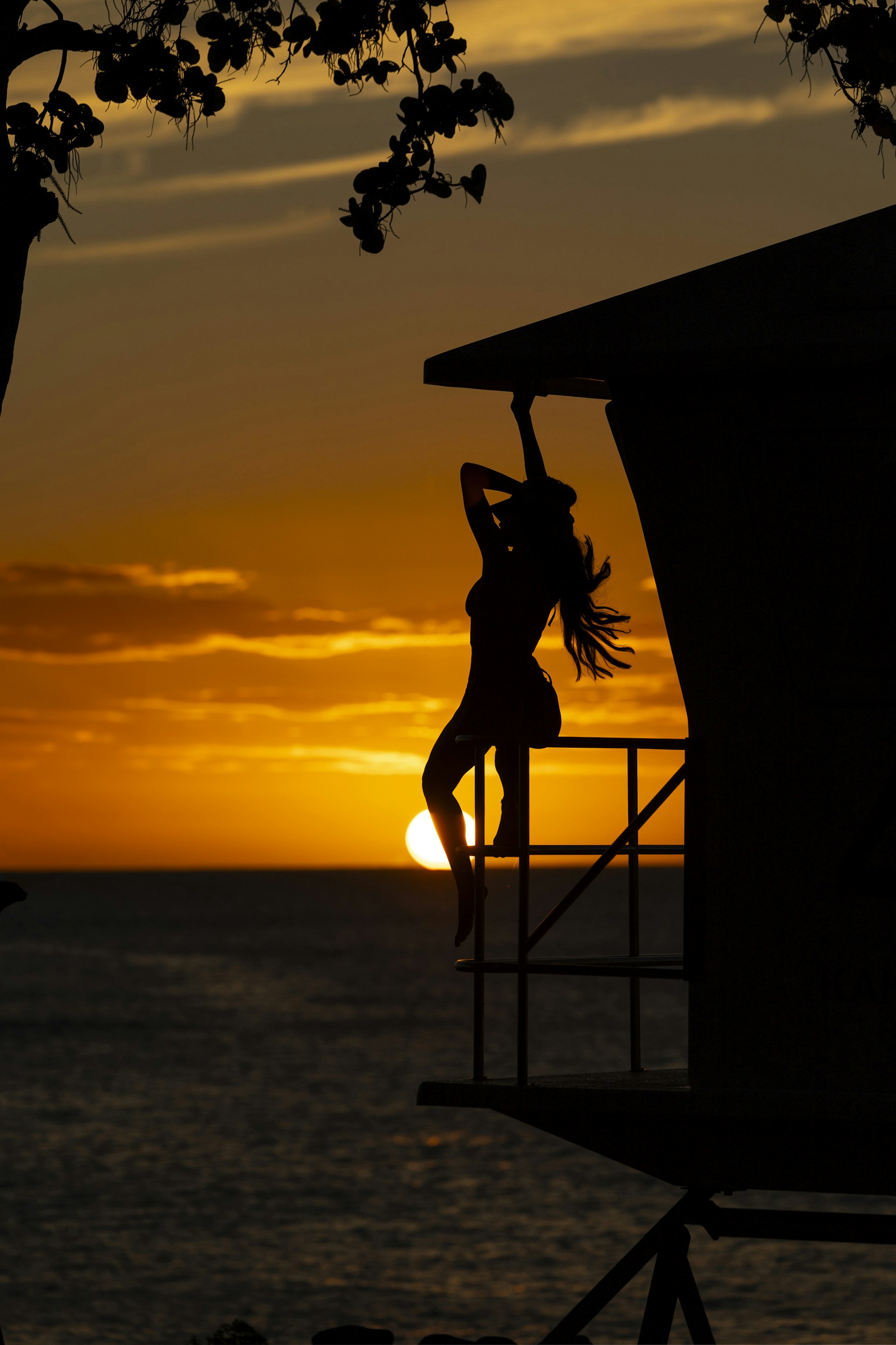 a silhouette of a woman doing a handstand in front of a sunset