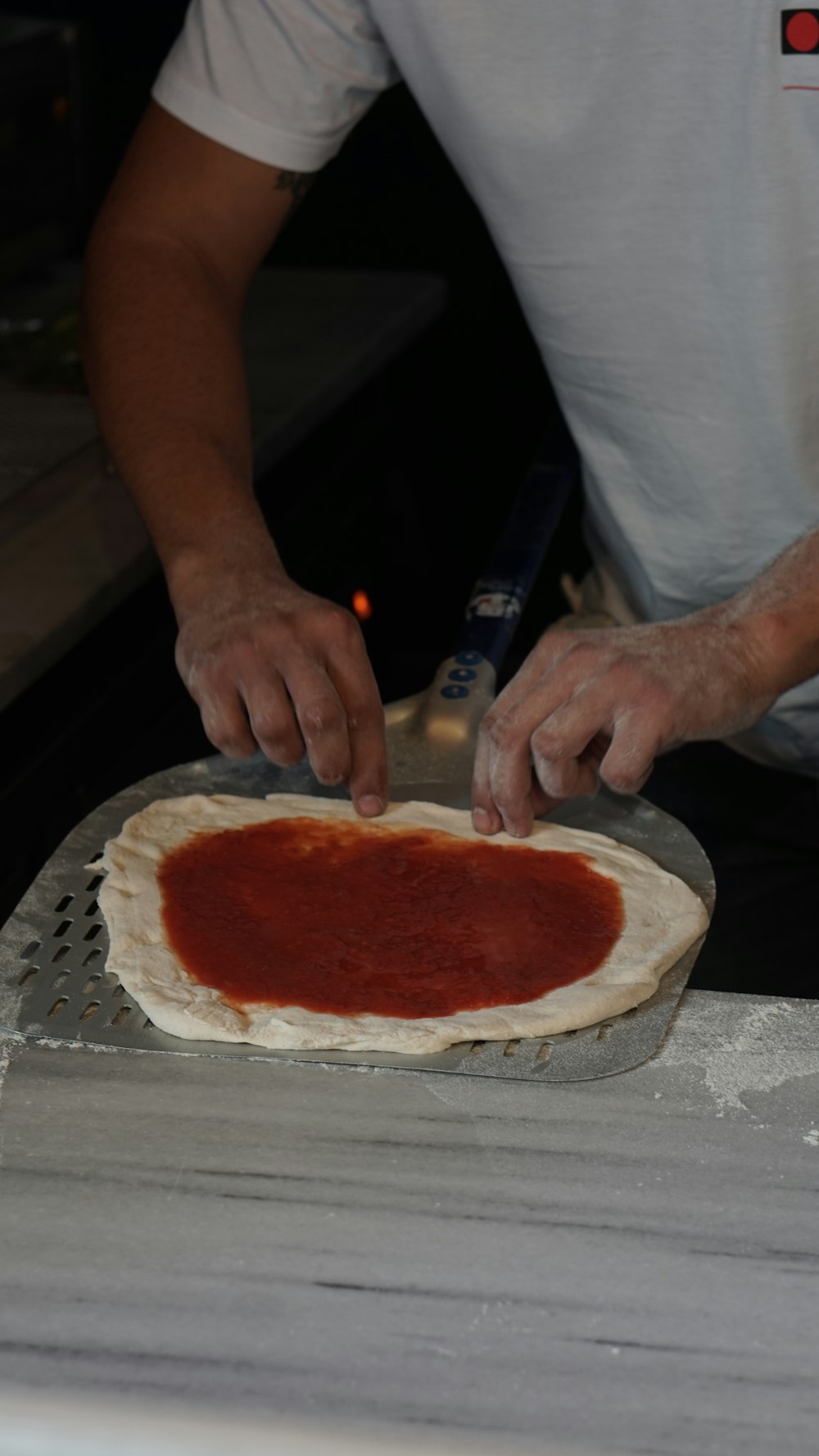 ein Mann, der eine Pizza auf einer Pizzaform macht