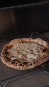 A happy customer receiving a freshly cooked pizza from the vending machine at night.