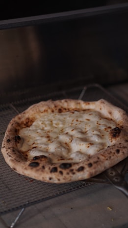 A golden, bubbling pizza fresh out of the oven with vibrant toppings.