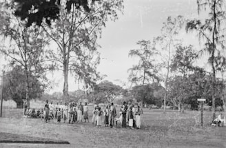 A diverse group of people showcasing trendy outfits in a park.