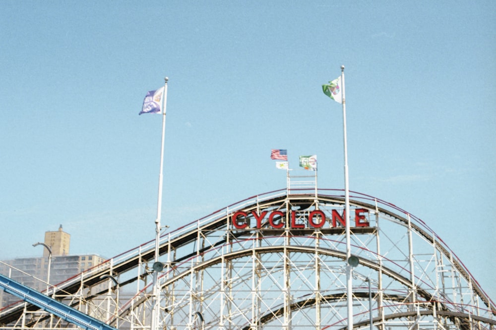 a roller coaster with flags flying in the wind
