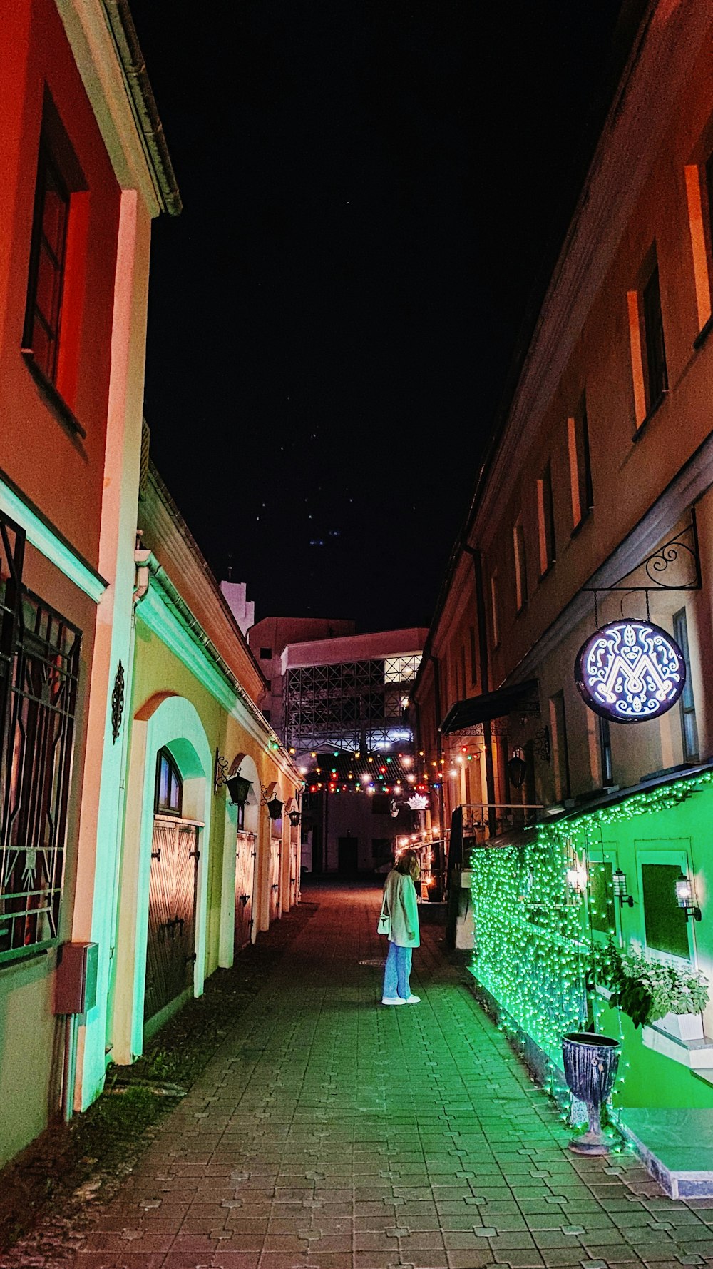 a person walking down a street at night