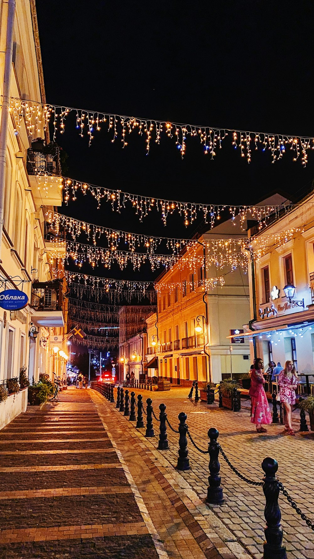 a street lined with buildings and lights at night