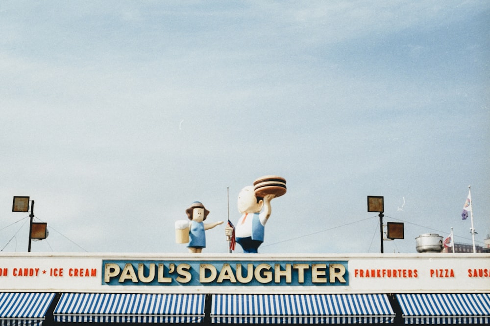 a couple of people standing on top of a sign