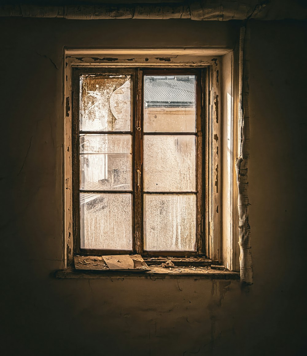 a window in an old building with peeling paint