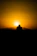 A shadowy silhouette of a lone gunslinger standing against a blood-red sunset.