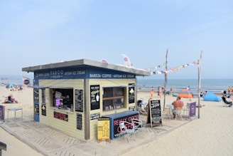 a small building on the beach with people on it