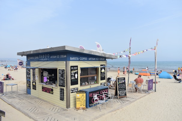 a small building on the beach with people on it