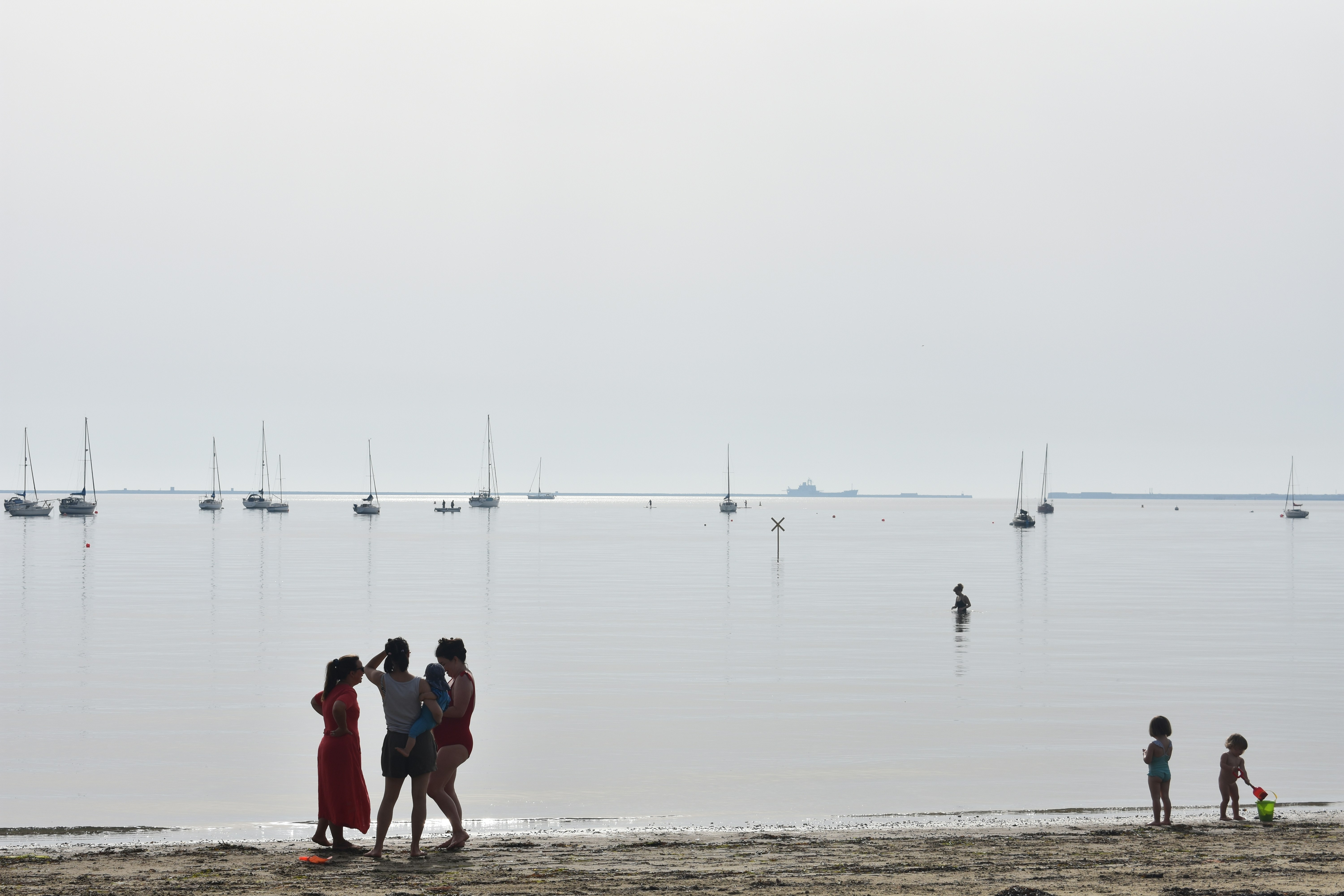 a group of people standing on top of a sandy beach