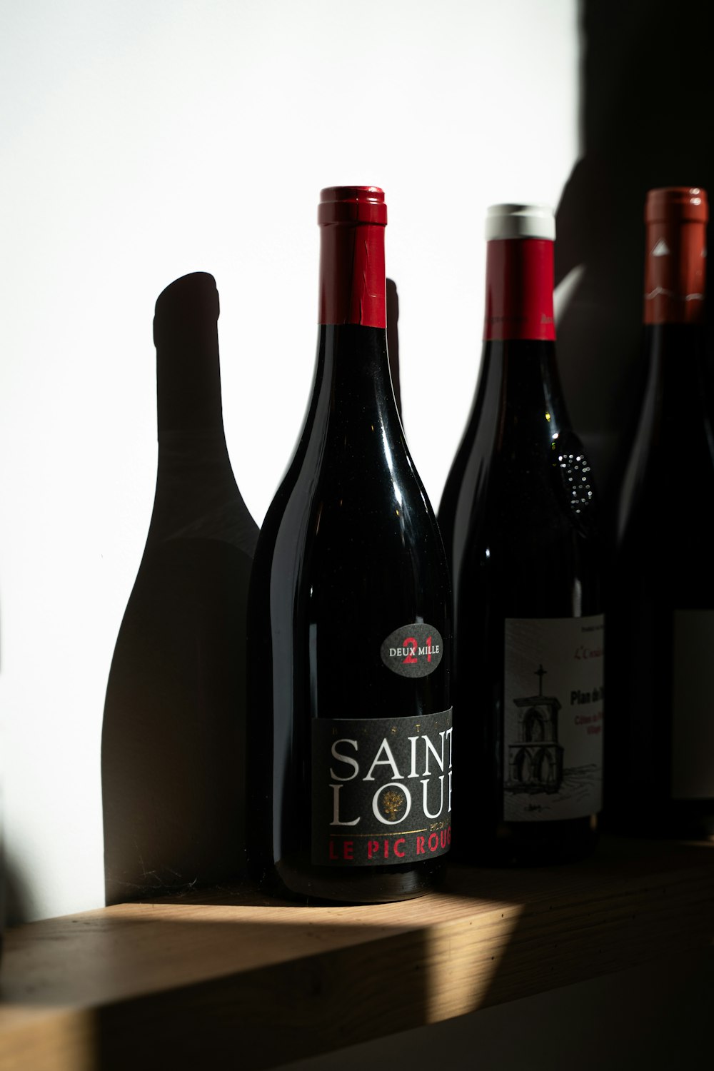 several bottles of wine are lined up on a shelf