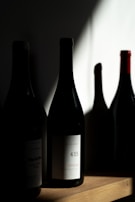 Bottles of local Lucanian wine resting on a wooden shelf.