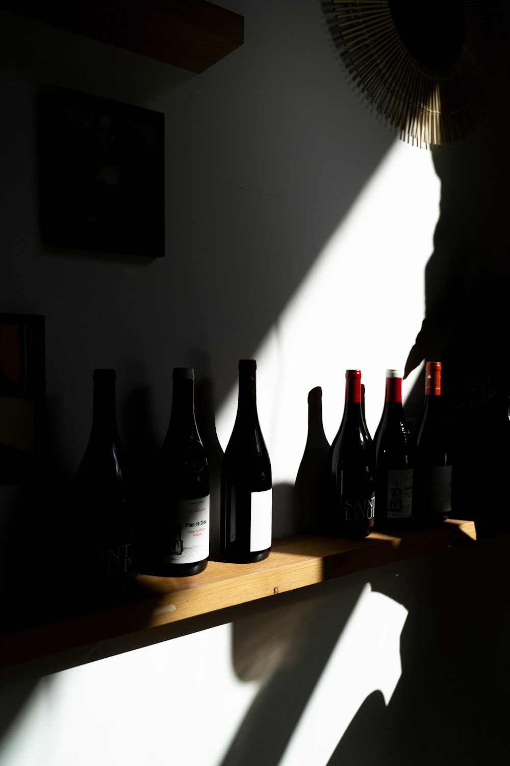 a person standing next to a shelf filled with bottles of wine