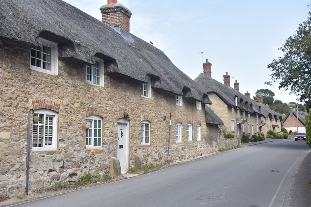 a row of stone houses with thatched roofs