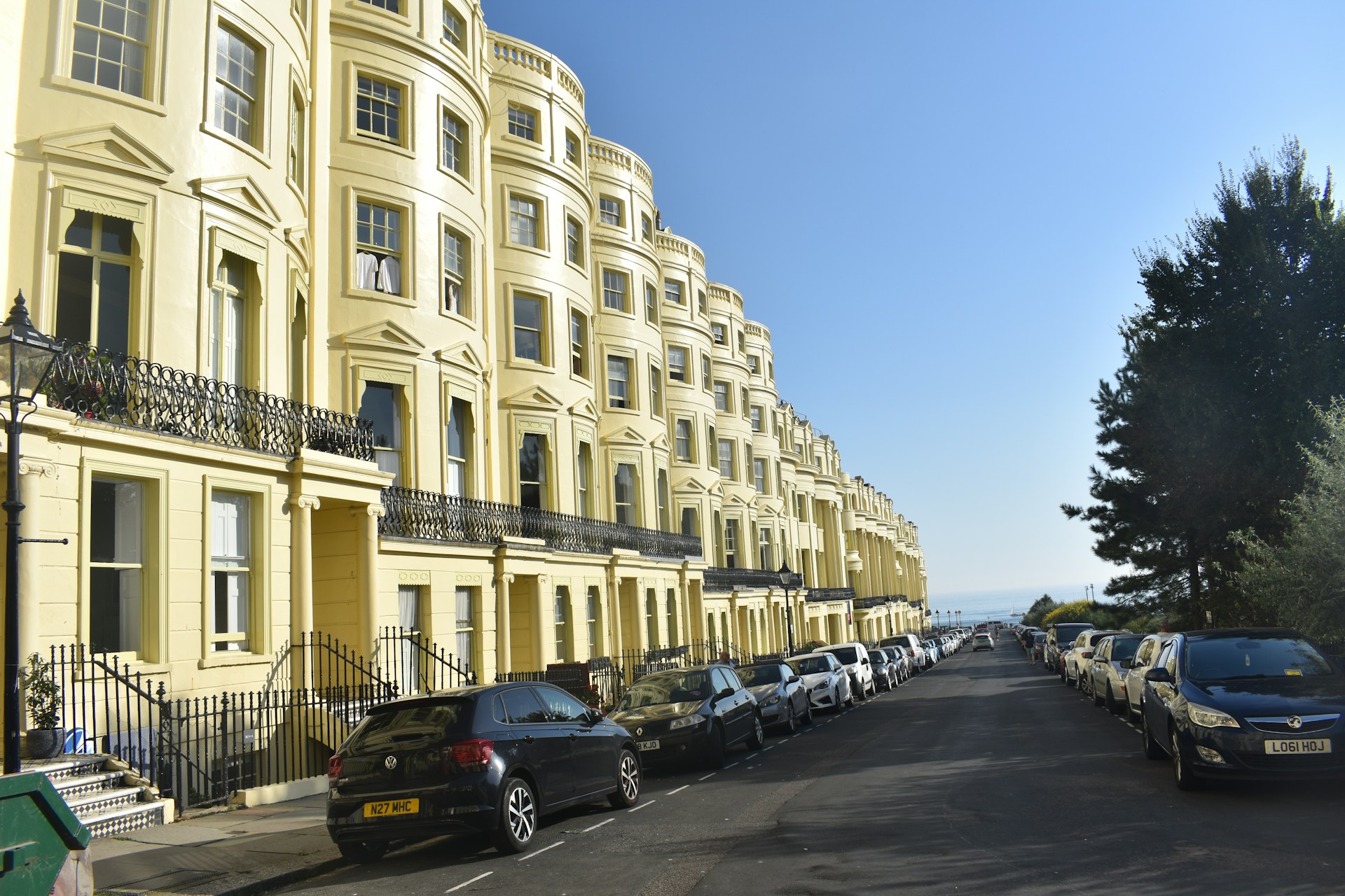 a street lined with parked cars next to tall buildings