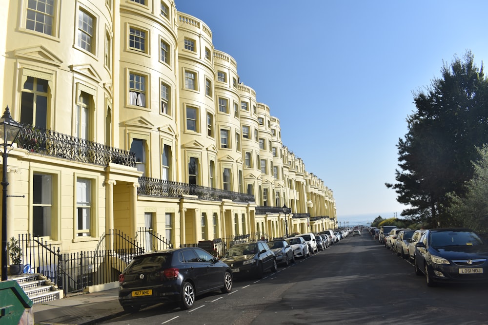 a street lined with parked cars next to tall buildings