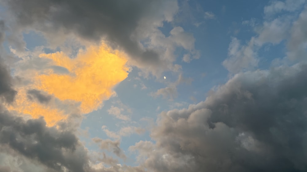 a plane flying through a cloudy blue sky