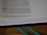A close-up of a Bible page featuring text from the book of Ezekiel, chapter 33. The page is open on a wooden surface, and part of a ribbon bookmark is visible at the bottom. The text is printed in black on a white background, with certain headings and numbers bolded for emphasis.