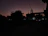 A softly lit silhouette of a city skyline at dusk, evoking a sense of discreet urban encounters.