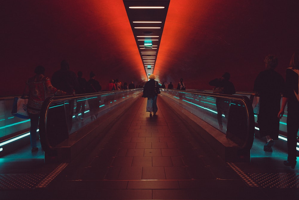 a group of people walking down a walkway at night