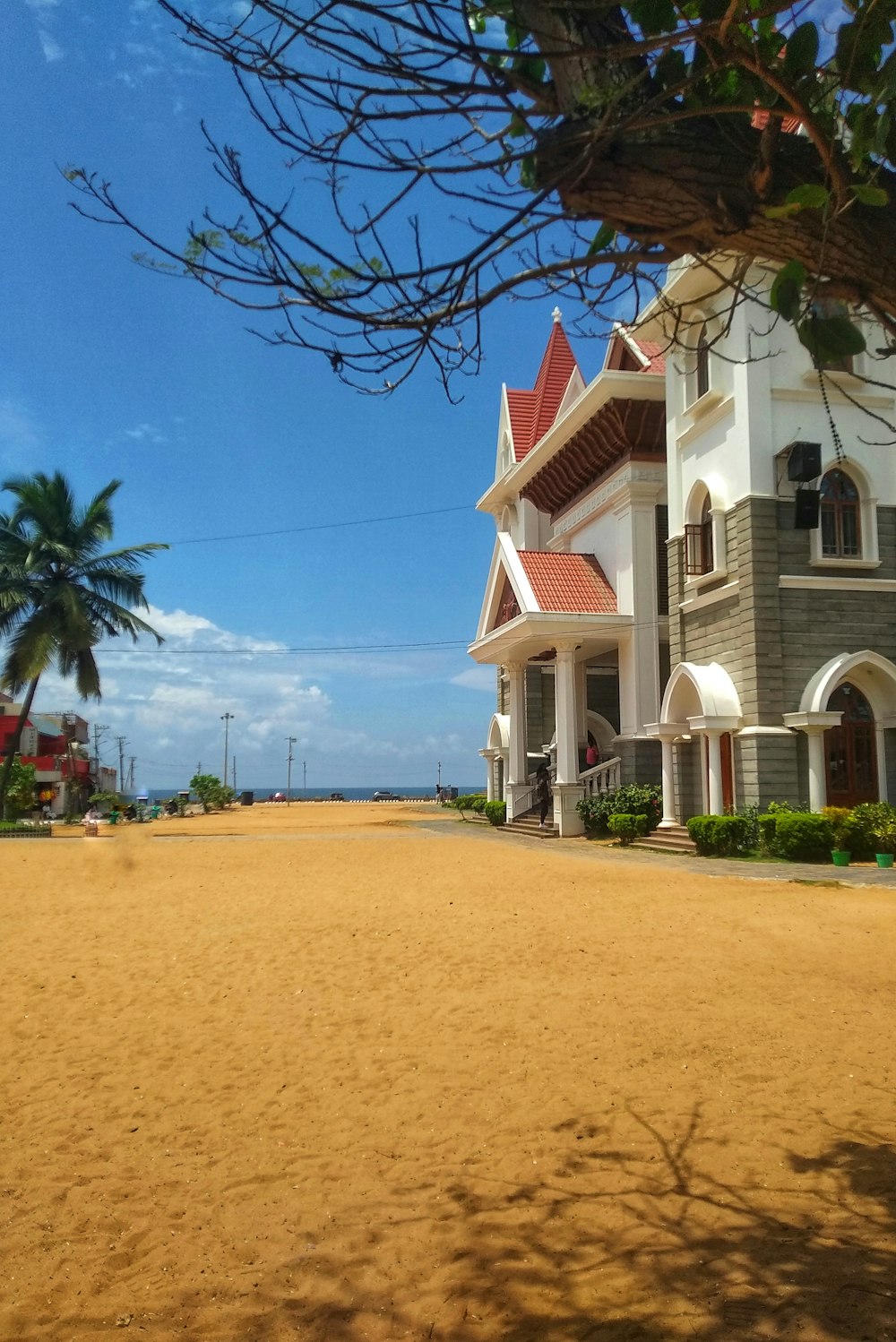 a large white house sitting on top of a sandy beach