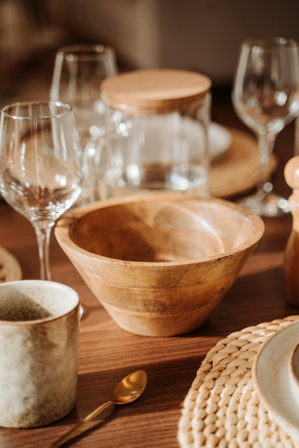 a wooden table topped with dishes and glasses