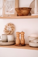 A collection of small wooden decor pieces arranged on a cozy kitchen shelf.