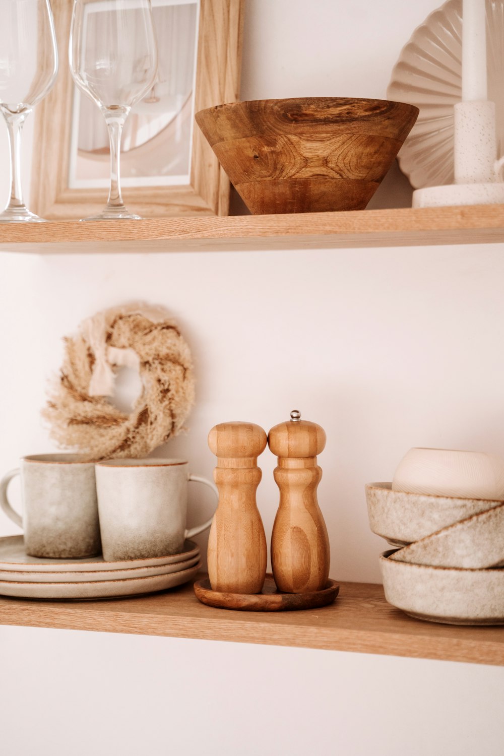 a shelf filled with dishes and cups on top of a wooden shelf